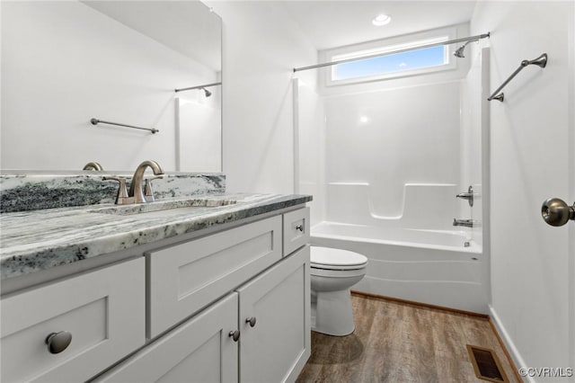 full bathroom with vanity, wood-type flooring, toilet, and washtub / shower combination