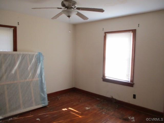 spare room featuring ceiling fan, plenty of natural light, and dark hardwood / wood-style flooring