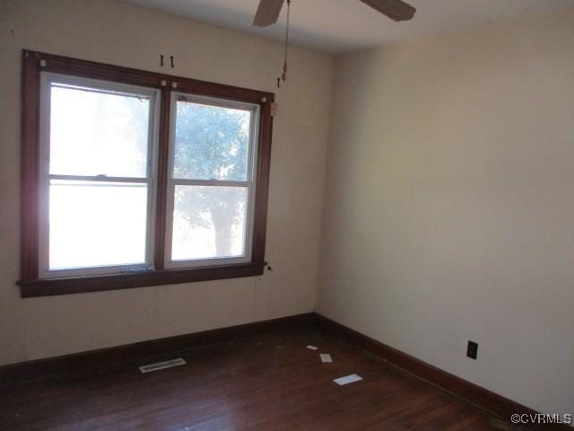 empty room featuring dark hardwood / wood-style flooring and ceiling fan