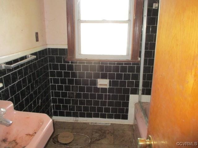 bathroom featuring tile patterned flooring and tile walls