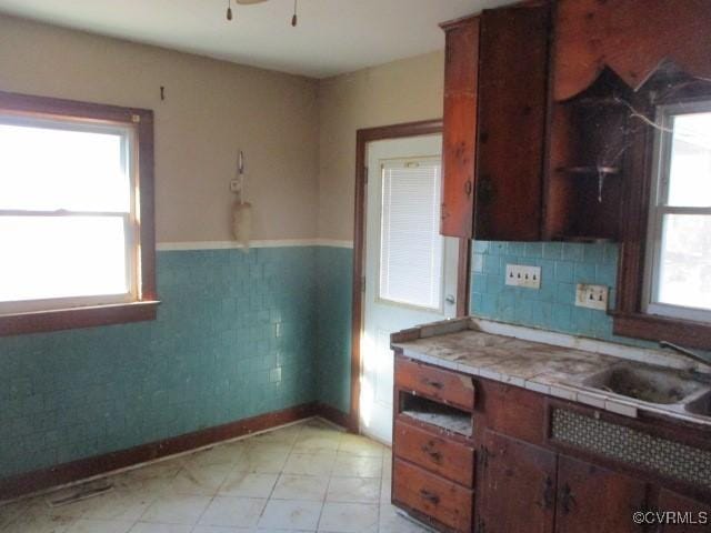 kitchen with sink, tile countertops, and ceiling fan