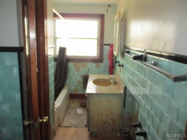 bathroom featuring washtub / shower combination, vanity, and wood-type flooring