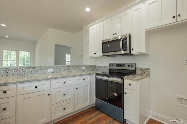 kitchen featuring stainless steel appliances, white cabinetry, light stone countertops, and dark hardwood / wood-style floors