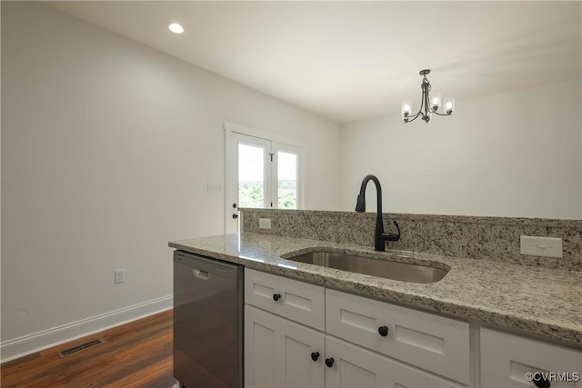 kitchen featuring white cabinetry, sink, stainless steel dishwasher, light stone counters, and an inviting chandelier