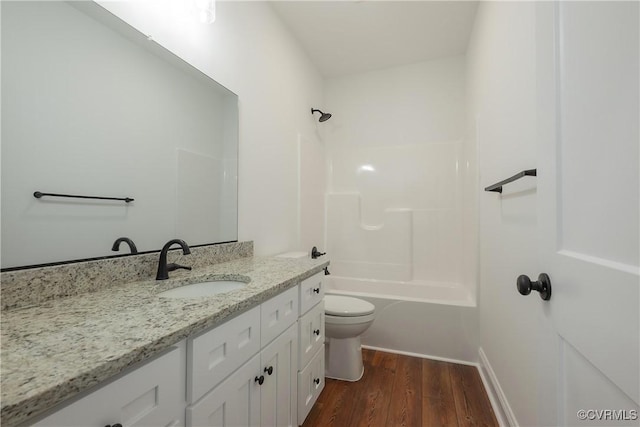 full bathroom with vanity, hardwood / wood-style floors, bathing tub / shower combination, and toilet