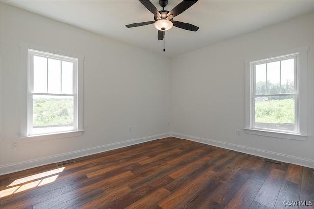 spare room with ceiling fan, a healthy amount of sunlight, and dark hardwood / wood-style flooring