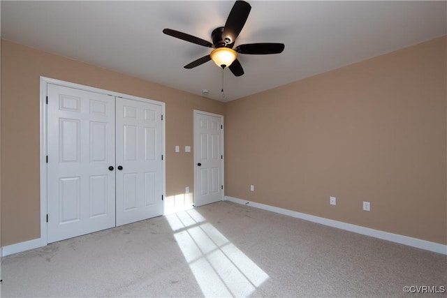 unfurnished bedroom featuring ceiling fan, a closet, and light carpet