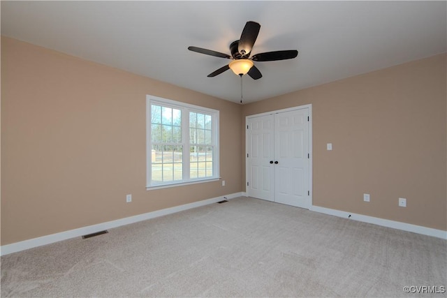 unfurnished room featuring light colored carpet and ceiling fan