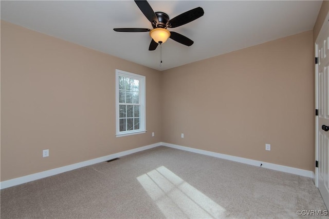 spare room with ceiling fan and light colored carpet