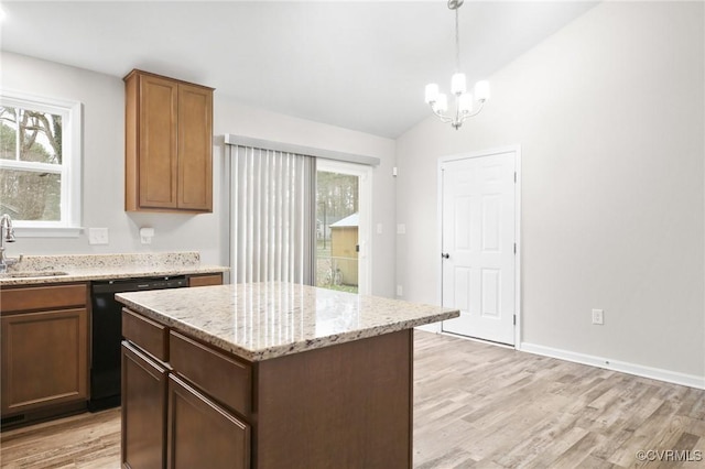 kitchen with vaulted ceiling, decorative light fixtures, black dishwasher, a center island, and light hardwood / wood-style floors