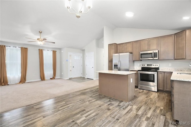 kitchen with sink, wood-type flooring, decorative light fixtures, a center island, and stainless steel appliances