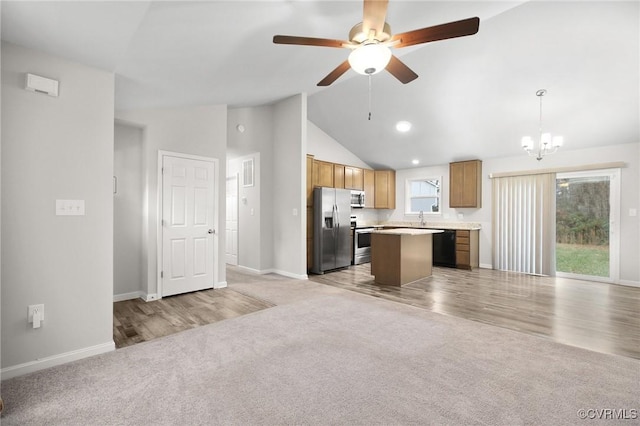 kitchen with a kitchen island, appliances with stainless steel finishes, a healthy amount of sunlight, and pendant lighting