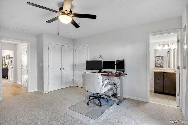 carpeted home office featuring ceiling fan