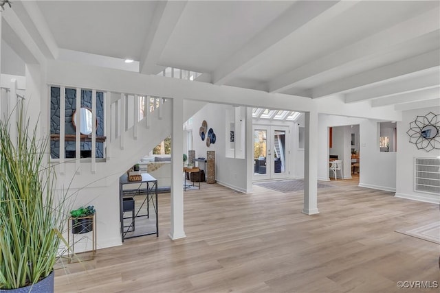 entrance foyer with beamed ceiling, light hardwood / wood-style floors, and french doors