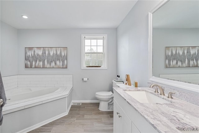 bathroom with vanity, a bathtub, and toilet