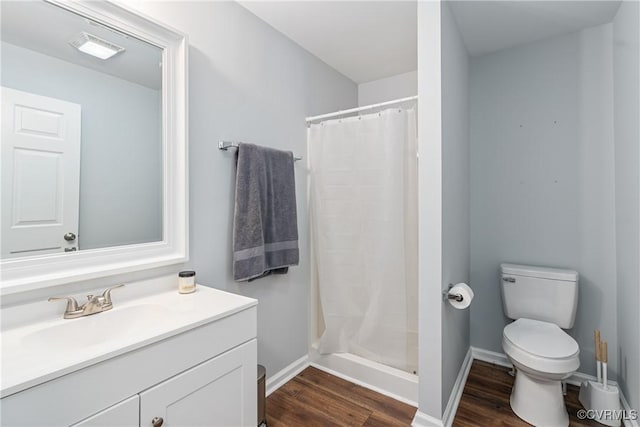 bathroom featuring vanity, hardwood / wood-style flooring, toilet, and a shower with shower curtain