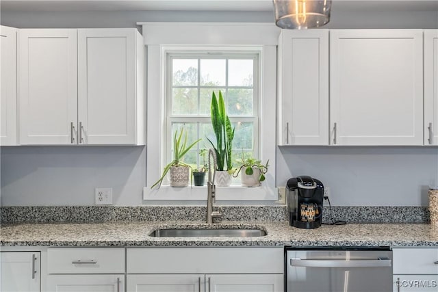 kitchen with white cabinetry, sink, light stone countertops, and dishwasher