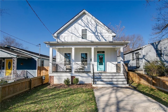 bungalow-style house with a front lawn and covered porch