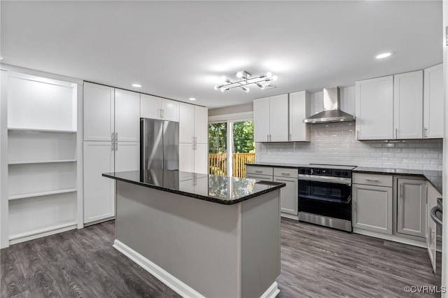 kitchen featuring white cabinets, dark stone counters, wall chimney exhaust hood, and appliances with stainless steel finishes