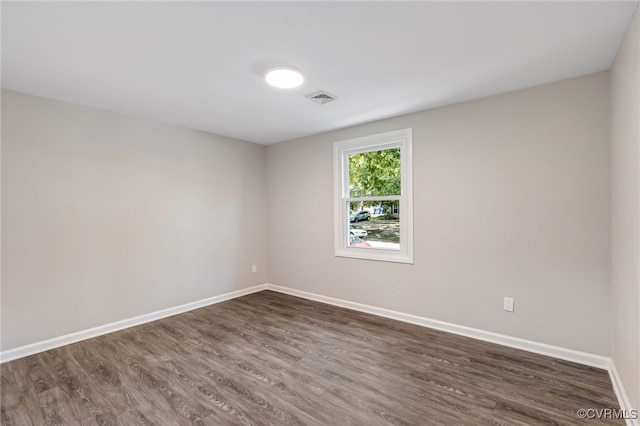 unfurnished room with dark wood-type flooring