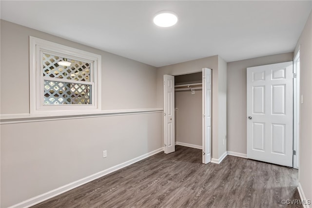 unfurnished bedroom with dark hardwood / wood-style floors and a closet