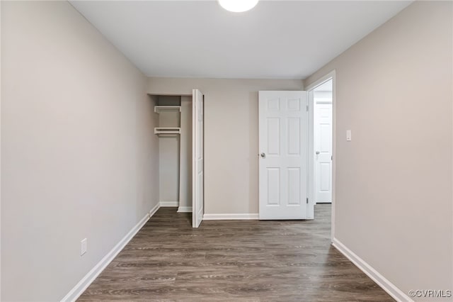 unfurnished bedroom with dark wood-type flooring and a closet