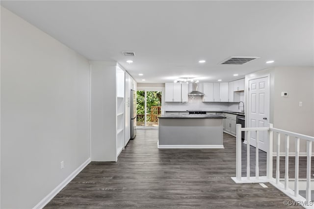 kitchen with wall chimney exhaust hood, sink, white cabinetry, stainless steel refrigerator, and decorative backsplash