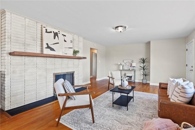 living room featuring a brick fireplace and hardwood / wood-style floors