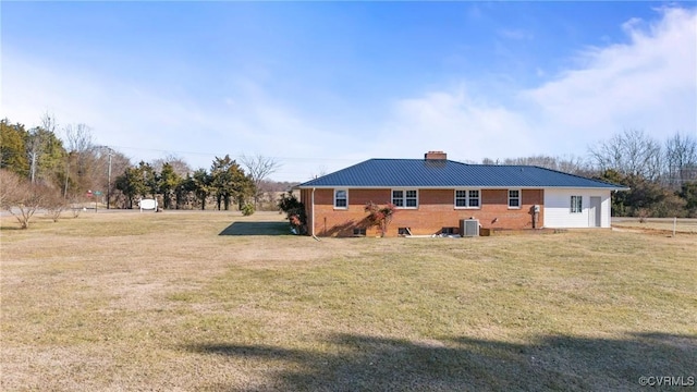 exterior space with central AC and a lawn