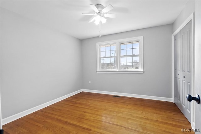 unfurnished bedroom with light hardwood / wood-style flooring, a closet, and ceiling fan