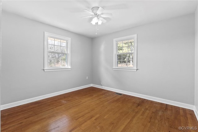 unfurnished room featuring plenty of natural light, hardwood / wood-style floors, and ceiling fan