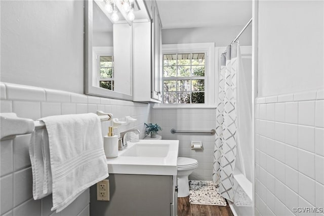 full bathroom featuring vanity, toilet, hardwood / wood-style floors, and tile walls