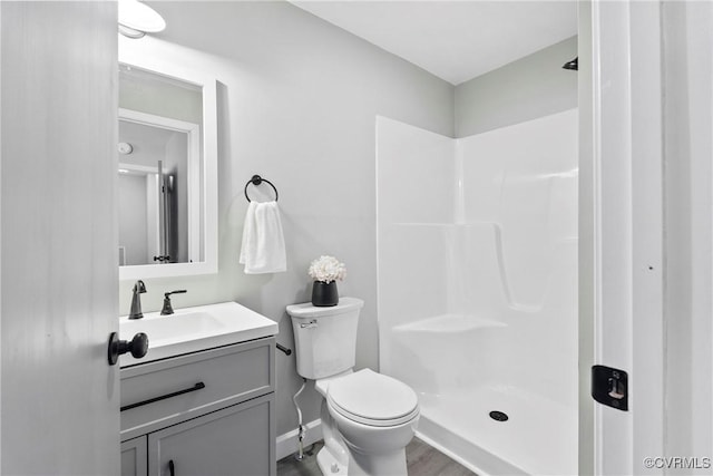 bathroom with vanity, hardwood / wood-style flooring, toilet, and walk in shower