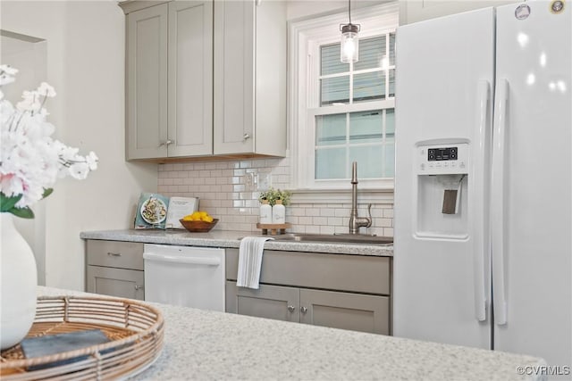 kitchen with sink, gray cabinetry, decorative light fixtures, white appliances, and backsplash