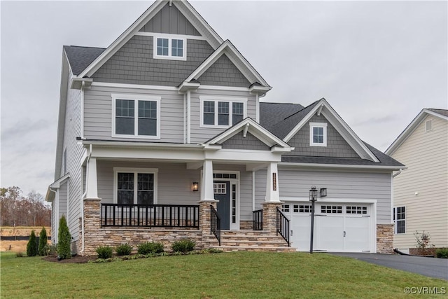 craftsman-style home with a garage, covered porch, and a front lawn