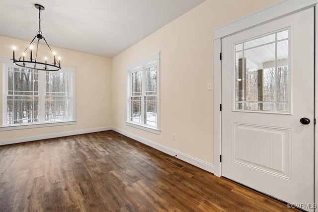 unfurnished dining area featuring dark hardwood / wood-style flooring and a chandelier