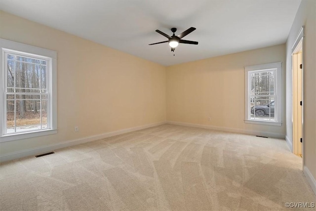 carpeted spare room with ceiling fan