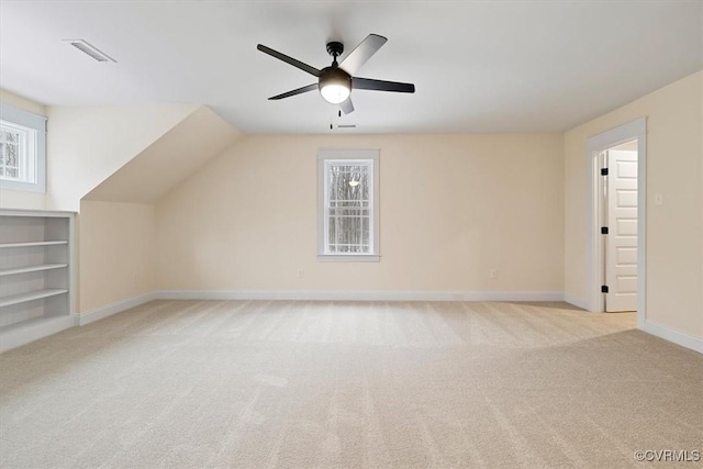 additional living space featuring vaulted ceiling, light colored carpet, and ceiling fan