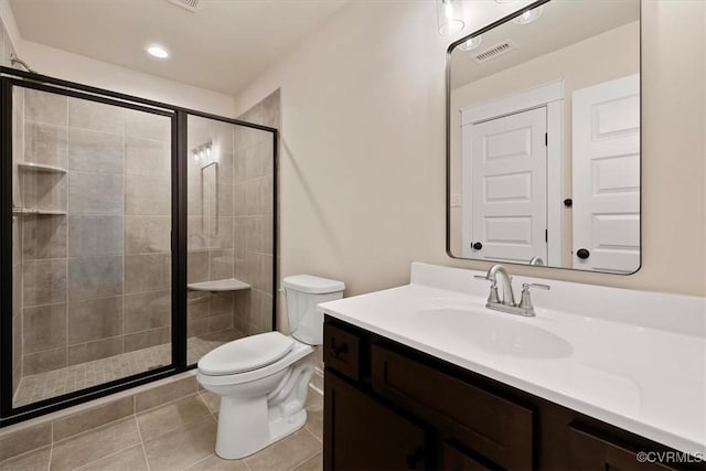 bathroom featuring walk in shower, vanity, toilet, and tile patterned flooring