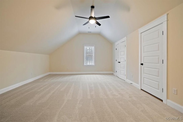 additional living space with light carpet, vaulted ceiling, and ceiling fan