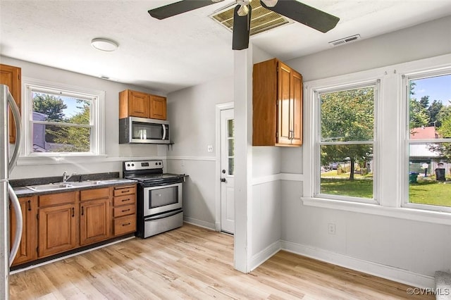 kitchen featuring sink, plenty of natural light, stainless steel appliances, and light hardwood / wood-style floors