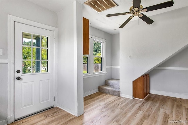 doorway to outside with ceiling fan and light wood-type flooring