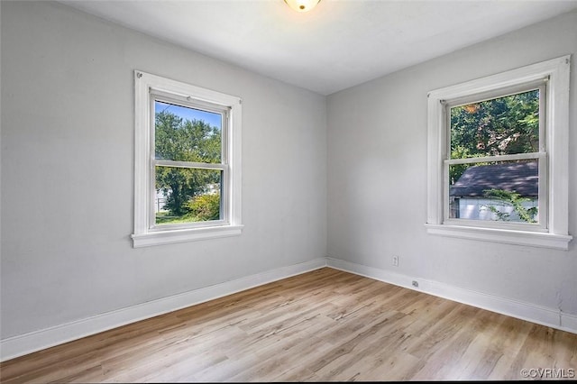 empty room with a healthy amount of sunlight and light hardwood / wood-style floors