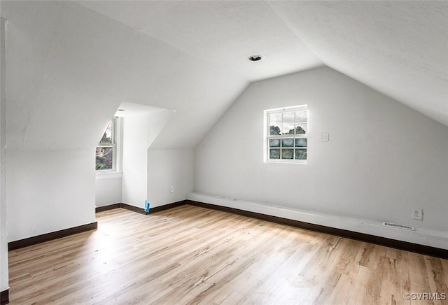 additional living space with lofted ceiling and light wood-type flooring