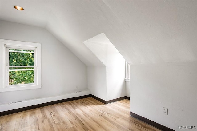 bonus room with lofted ceiling and light hardwood / wood-style floors