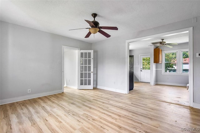 unfurnished room with ceiling fan, light hardwood / wood-style floors, and a textured ceiling