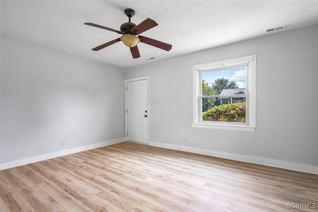 unfurnished room with a textured ceiling, ceiling fan, and light wood-type flooring