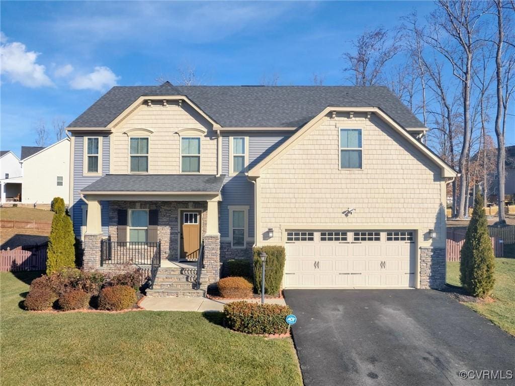 view of front of home featuring a garage, a porch, and a front lawn