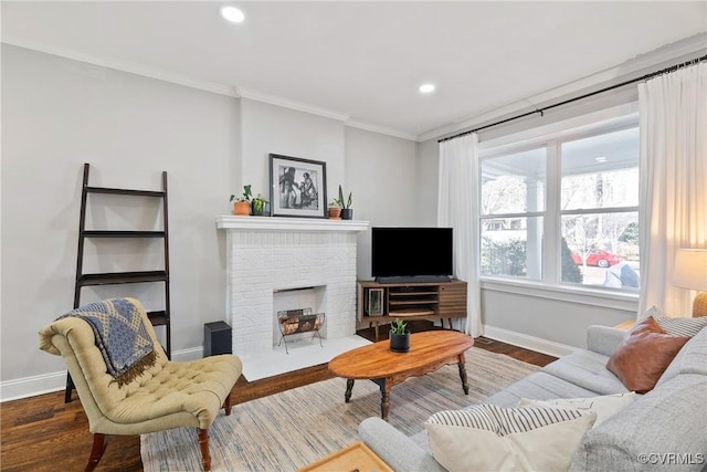 living room featuring ornamental molding, wood-type flooring, and a brick fireplace