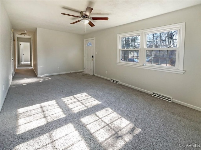 carpeted spare room featuring ceiling fan